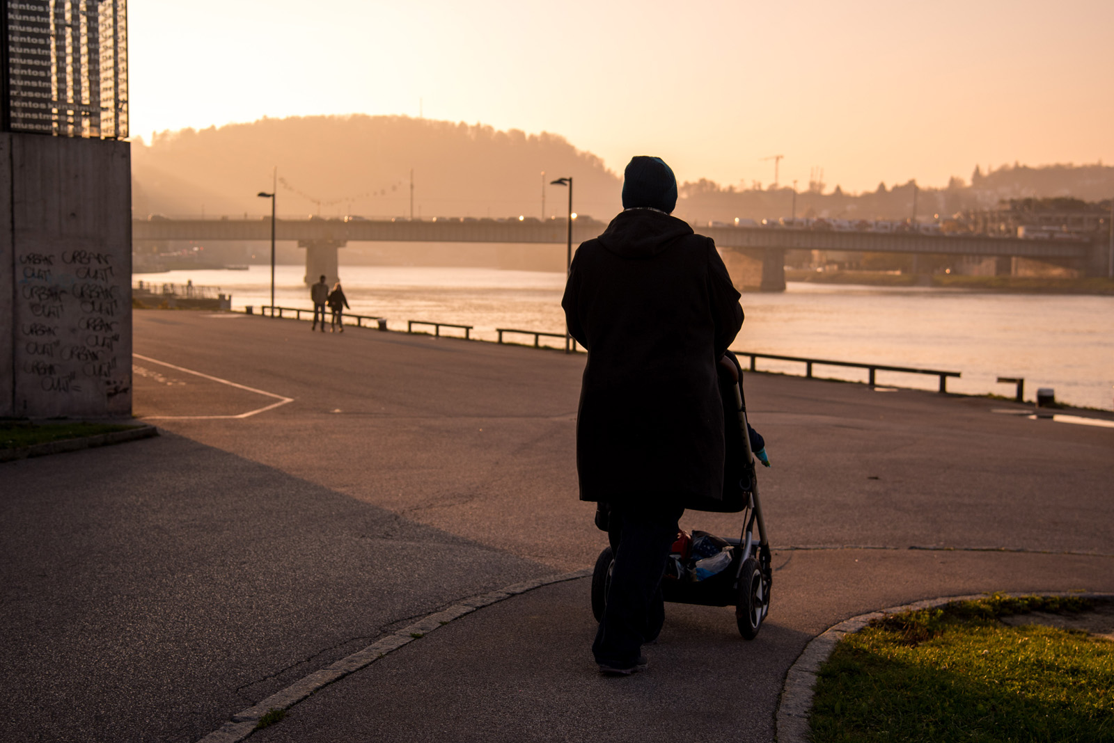 Person mit Kinderwagen an der Donau