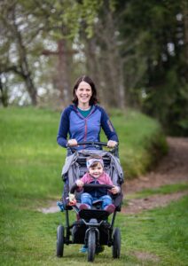 Frau mit Kind im Kinderwagen
